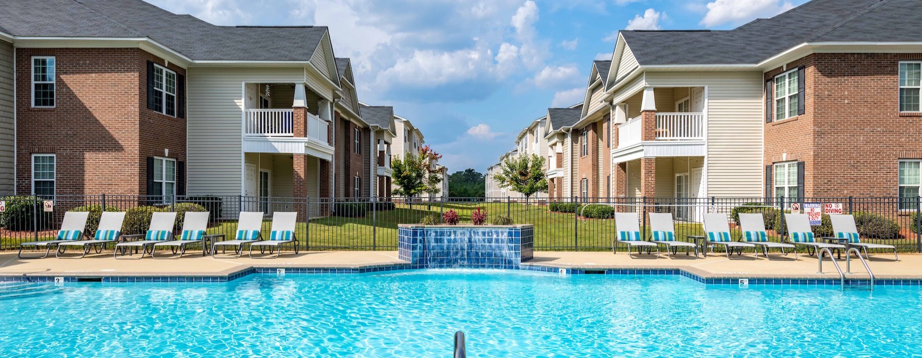 a swimming pool behind an apartment complex