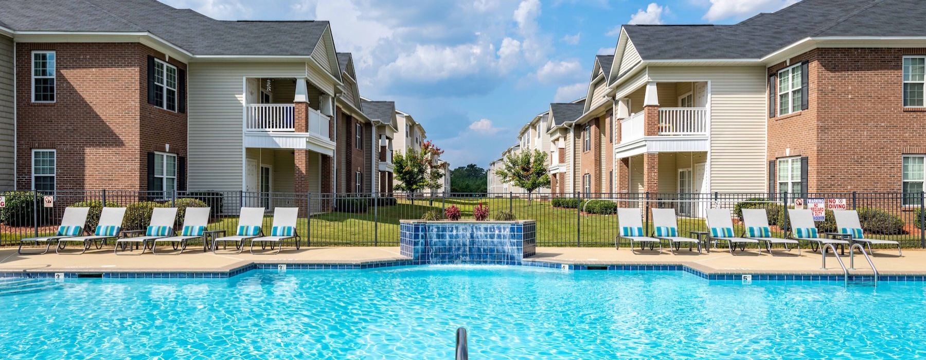 a swimming pool behind an apartment complex