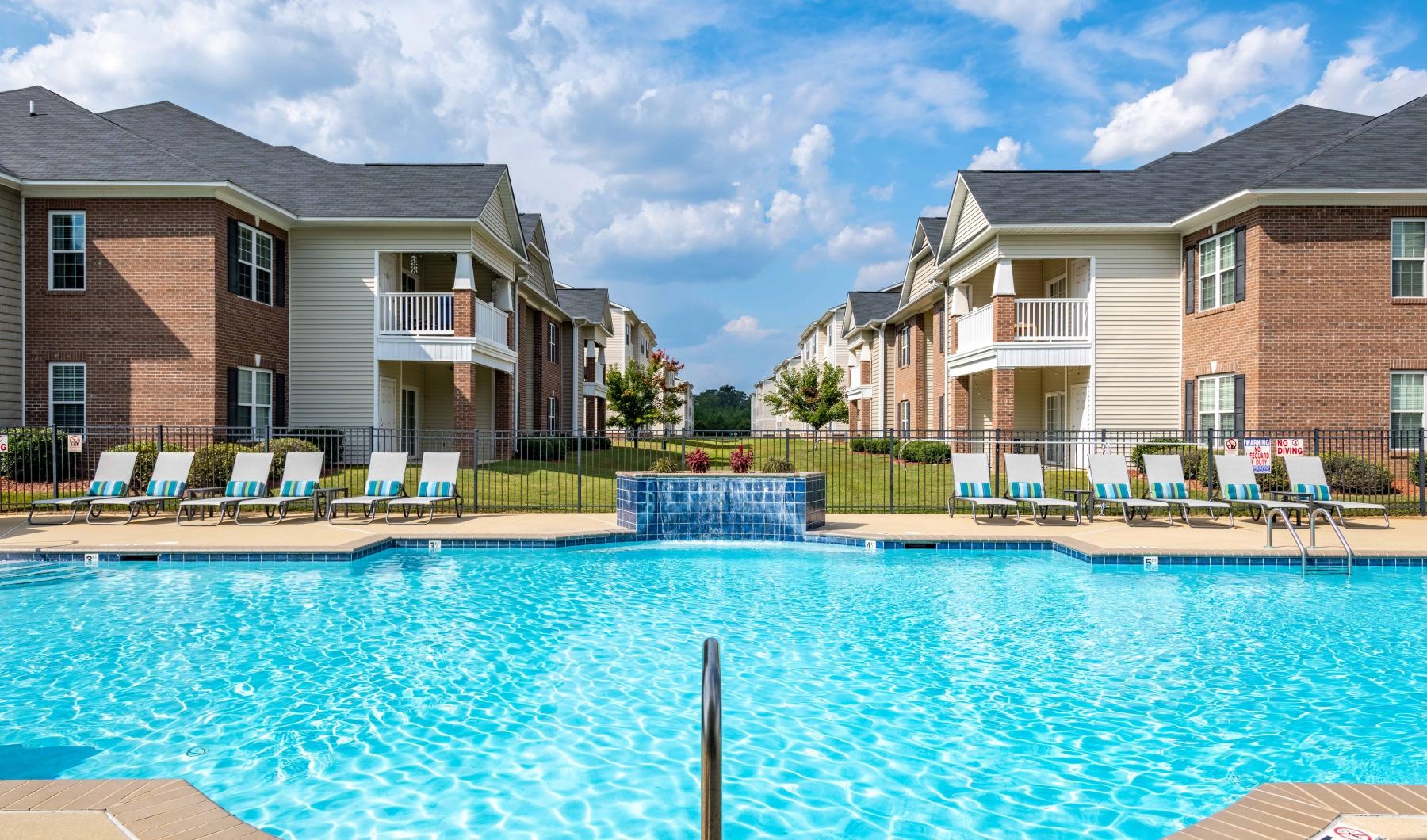 a swimming pool behind an apartment complex