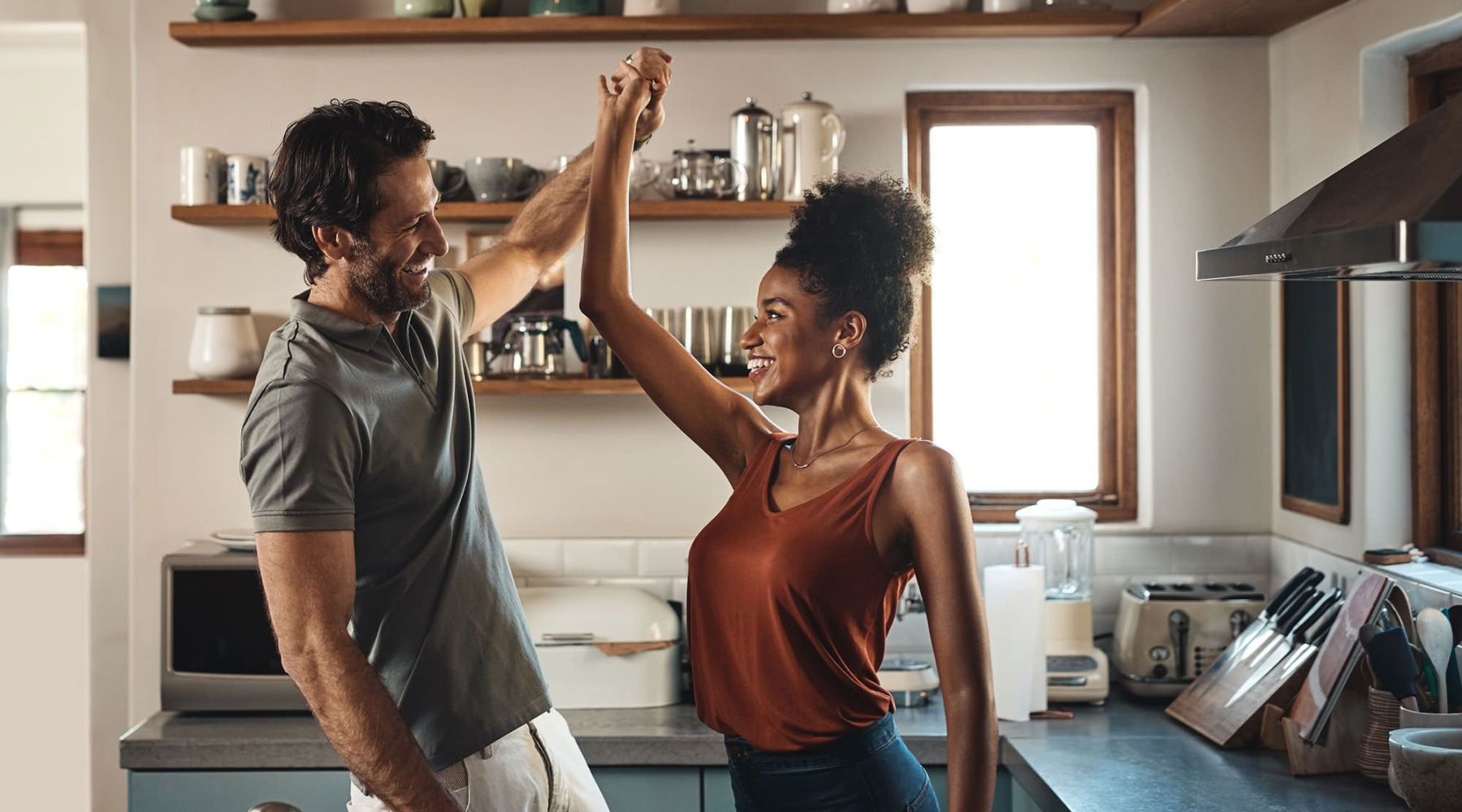 a couple high-fiving in a kitchen