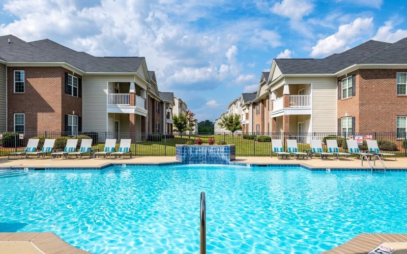 a swimming pool behind an apartment complex